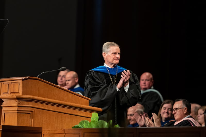 Élder David A. Bednar, do Quórum dos Doze Apóstolos, aplaude o presidente Henry J. Eyring, da BYU-Idaho, durante a formatura realizada no BYU-I Center em Rexburg, Idaho, em 19 de julho de 2023.