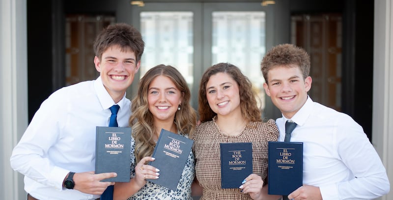 Irmãos Eli, Elle, Isabel e Isaac Reid seguram cópias do Livro de Mórmon nos respectivos idiomas que aprenderão como missionários.
