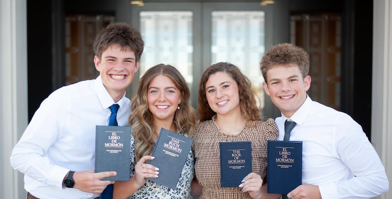 Irmãos Eli, Elle, Isabel e Isaac Reid seguram cópias do Livro de Mórmon nos respectivos idiomas que aprenderão como missionários.