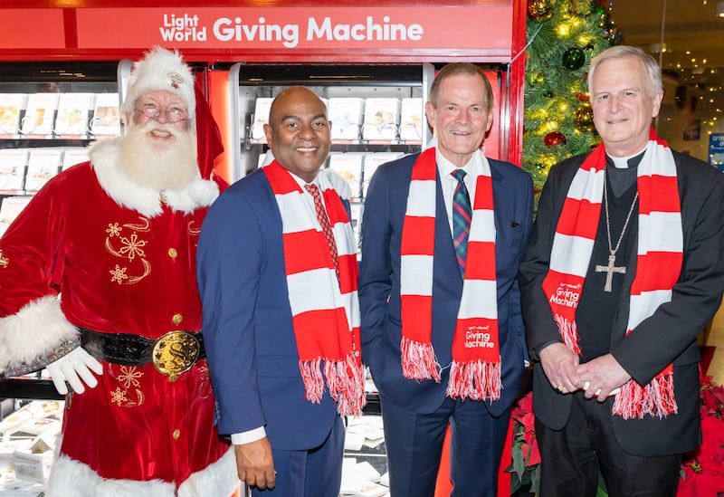 Da esquerda para a direita: Papai Noel; Elder Michael Ortiz, uma Setenta Autoridade Geral, Elder Gary E. Stevenson do Quórum dos Doze Apóstolos; e Bispo James V. Johnston, da Diocese Católica de Kansas City-St. Joseph, posam para uma foto em um evento para lançar os quiosques da Light the World Giving Machine dentro da Union Station no centro de Kansas City, Missouri, no sábado, 22 de novembro de 2025.