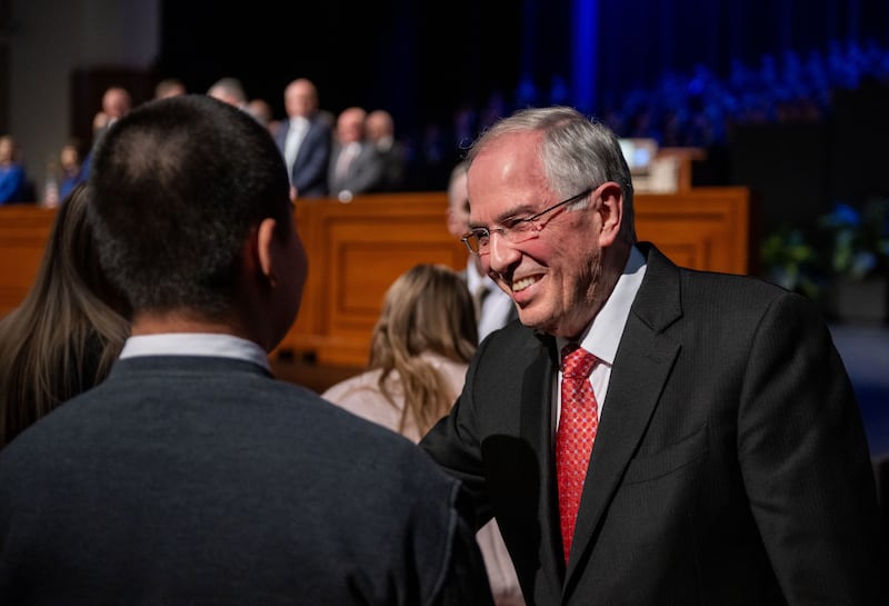 Elder Neil L. Andersen do Quórum dos Doze Apóstolos cumprimenta os alunos reunidos no BYU–I Center durante o devocional no domingo, 22 de fevereiro de 2026, em Rexburg, Idaho.