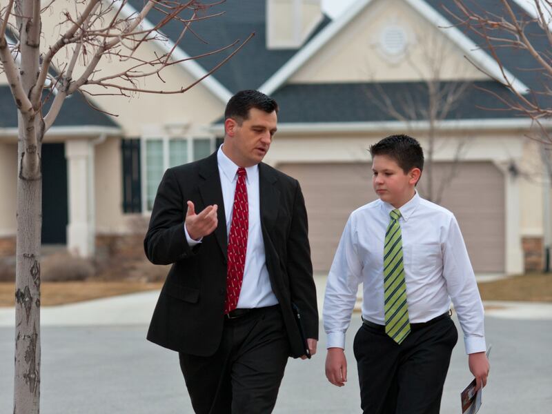 A father and son walk down the street as they go to a ministering appointment together.