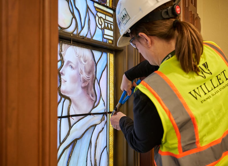 Um membro da equipe coloca meticulosamente painéis de vidro artístico nos edifícios da entrada norte na Praça do Templo em Salt Lake City na quarta-feira, 11 de março de 2026.