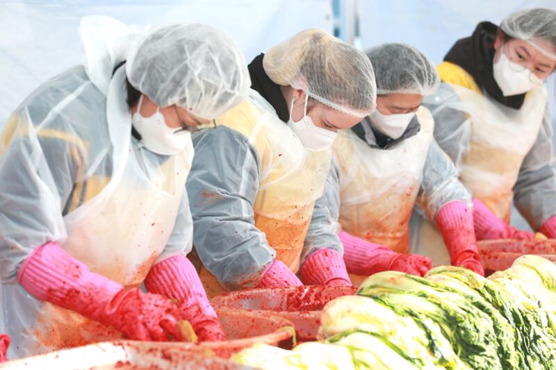 Quatro pessoas da Estaca Changwon, na Coreia, preparam kimchi durante o "Festival de Compartilhamento de Kimchi com Amor" em Changwon, Coreia do Sul, em 12 de dezembro de 2025.