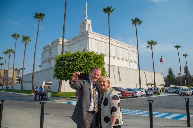 Elder Gary E. Stevenson do Quórum dos Doze Apóstolos tira uma selfie com sua esposa, a irmã Lesa Stevenson, em frente ao Templo da Cidade do México.