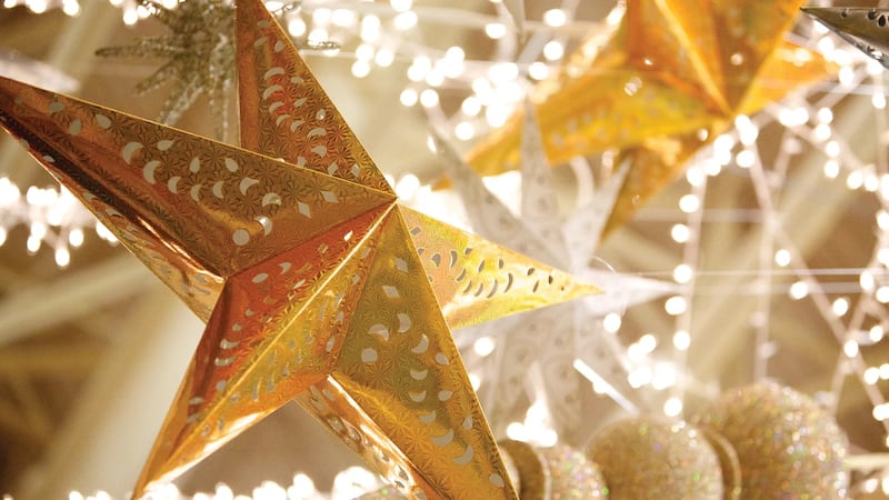 Enfeites de estrela de Natal dourados são pendurados como decorações em celebração ao Natal. Estrelas são frequentemente usadas nas decorações de Natal para representar a Estrela de Belém