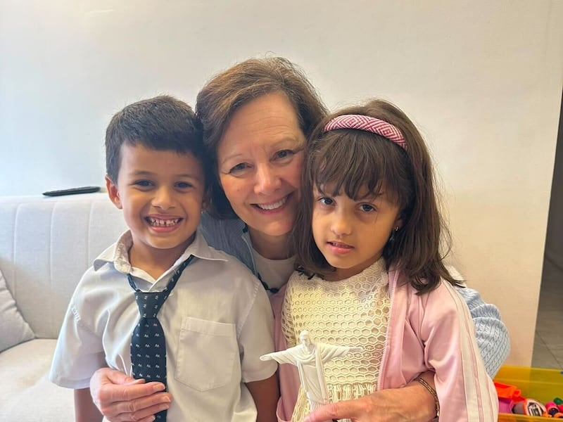 Presidente Geral da Primária Susan H. Porter, centro, tira uma foto com duas crianças no Brasil, sábado, 13 de junho de 2026.