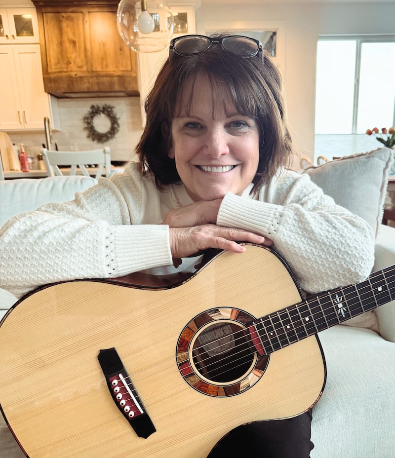 Shawna Edwards — compositora de "The Miracle", uma nova adição a Hymns for Home and Church — posa para uma foto com uma guitarra em Lehi, Utah, janeiro de 2025.