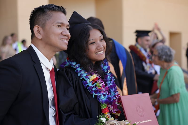 Formandos da BYU–Hawaii comemoram com a família e amigos do lado de fora do Cannon Activities Center em Laie, Havaí, após a formatura na sexta-feira, 12 de dezembro de 2025.