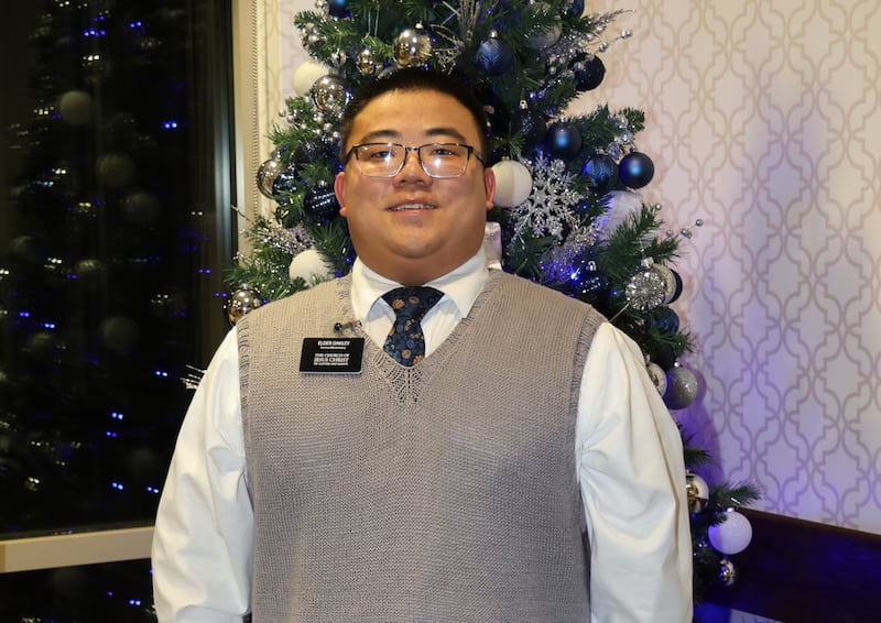 Élder Emmett Oakley, um missionário de serviço de Cedar Falls, Iowa, está em frente a uma árvore de Natal em 17 de dezembro de 2025.