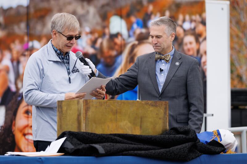 O bibliotecário da BYU Rick Anderson, à esquerda, ouve enquanto Vance Campbell, à direita, lê uma carta incluída na cápsula do tempo que foi colocada na biblioteca em 1976 durante o aniversário de centenário de Brigham Young University. A cápsula do tempo foi aberta durante um evento do Dia do Fundador na Praça Brigham em Provo, Utah, na quinta-feira, 16 de outubro de 2025.