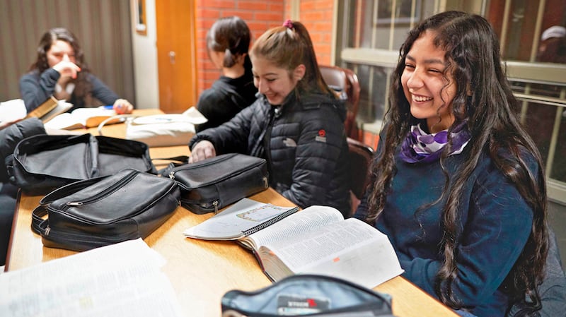 Rapazes e moças assistem a uma aula de seminário no início da manhã na Argentina.