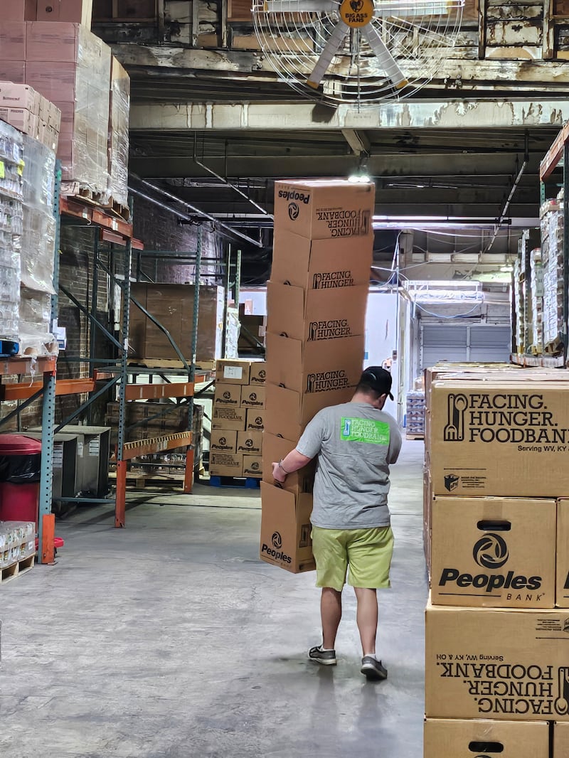 Elder Welch carrega uma pilha de caixas no Facing Hunger Food Bank em Huntington, West Virginia em ______.