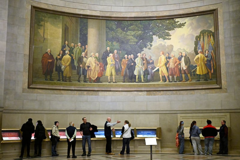 Um grande mural na parede mostrando a assinatura da Declaração da Independência é visto acima dos visitantes dos Arquivos Nacionais, 29 de janeiro de 2026, em Washington, D.C.