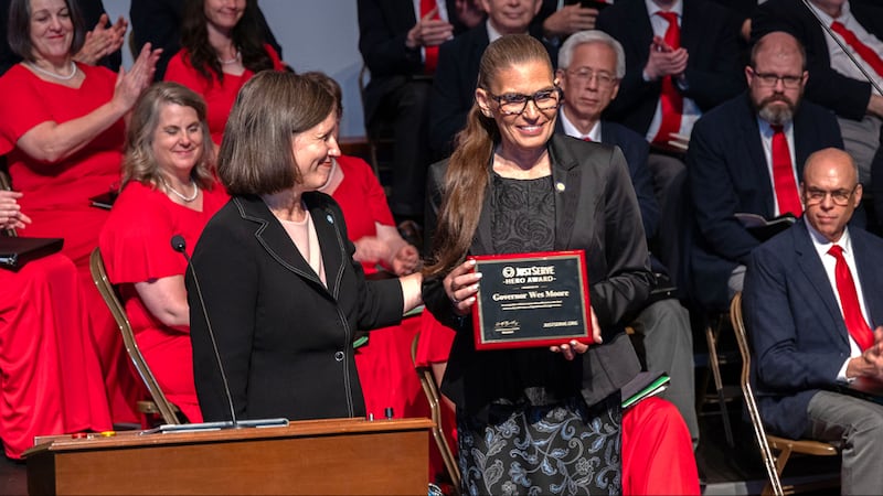 O Prêmio Herói do JustServe apresentado ao governador de Maryland, Wes Moore, é aceito por sua conselheira sênior, Maria Martinez, durante a celebração do 50º aniversário da dedicação do Centro de Visitantes do Templo de Washington D.C. de A Igreja de Jesus Cristo dos Santos dos Últimos Dias em 13 de junho de 2026, em Kensington, Maryland.