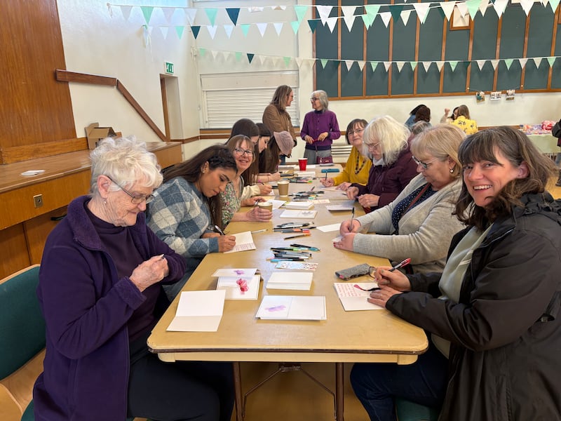 Irmãs da Sociedade de Socorro do Ramo Huntingdon fazem cartões para pacientes no Hospital Hinchingbrooke, em Northampton, Inglaterra, 14 de março de 2026.