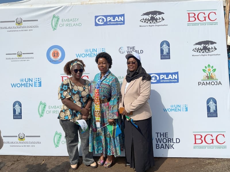 Irmã Judith Spendi, Assessora de Organização de Área da Igreja (ao centro), posa para uma foto com autoridades do ministério em frente a um banner exibindo nomes de organizações que apoiaram o ministério nas preparações para as celebrações do Dia Internacional da Mulher em 8 de março de 2026, em Geita, Tanzânia.