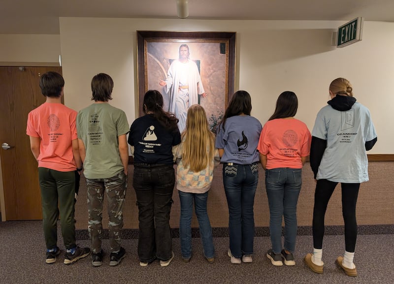 Os jovens da Ala Marshfield em Marshfield, Missouri, tiram uma foto em 4 de fevereiro de 2026, mostrando o que está escrito nas costas das camisetas que eles fizeram para um conferência "Para o Vigor dos Adultos".