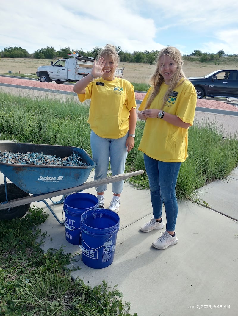 Missionárias da Missão Colorado Colorado Springs trabalham no jardim no centro de uma rotatória em Fountain, Colorado, como parte de um dia de serviço, em 2 de junho de 2023.