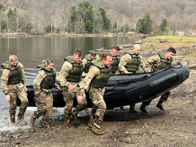 A Equipe do Desafio Ranger ROTC da BYU carrega embarcações infláveis para a costa durante a competição de habilidades militares Sandhurst 2022, em West Point, Nova York.