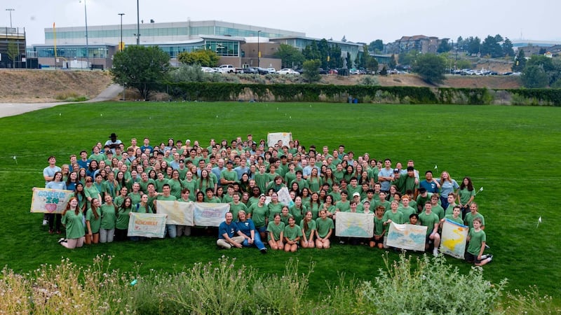 Dezenas de jovens posam para uma foto em grupo em um grande campo na conferência Para a Força da Juventude em Kamloops, Colúmbia Britânica, Canadá, em agosto de 2026.