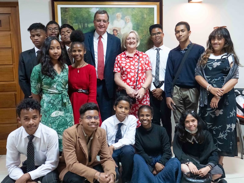 O presidente geral da Escola Dominical, Mark L. Pace, e sua esposa, a irmã Anne Marie Pace, posam para uma foto com os jovens locais durante uma sessão de instrução em Antananarivo, Madagascar, em 30 de outubro de 2022.