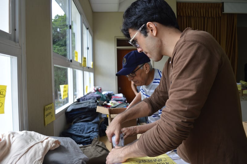 Voluntários de A Igreja de Jesus Cristo dos Santos dos Últimos Dias classificam e embrulham roupas doadas para os sobreviventes dos terremotos na Venezuela em 29 de junho de 2026.
