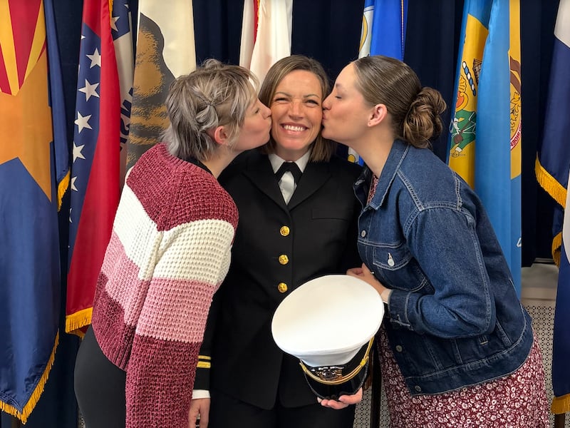 Ao centro, a Tenente j.g. Stacie Powell, a primeira mulher Capelão da Marinha em serviço ativo apoiada por A Igreja de Jesus Cristo dos Santos dos Últimos Dias, é beijada por suas filhas Pearl Wise e Paige Cole após sua formatura na Naval Station Newport em Newport, Rhode Island, em novembro de 2025.