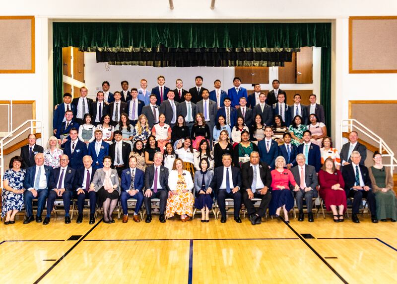 Missionários da Missão Califórnia Oakland/San Francisco tiram uma grande foto em grupo ao lado do palco de uma capela durante uma conferência de zona em 2025.