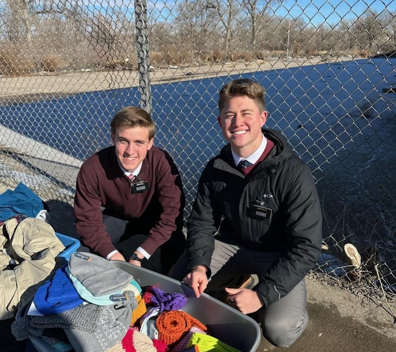 Élder Logan Hall e élder William Welsh se preparam para distribuírem roupas doadas para os necessitados em Pueblo, Colorado, em 25 de dezembro de 2023.