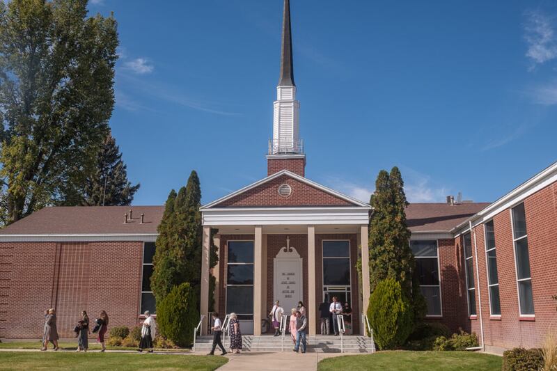 Pessoas saindo da sede da estaca Enterprise Utah de A Igreja de Jesus Cristo dos Santos dos Últimos Dias depois da conferência no domingo, dia 17 de outubro de 2021.