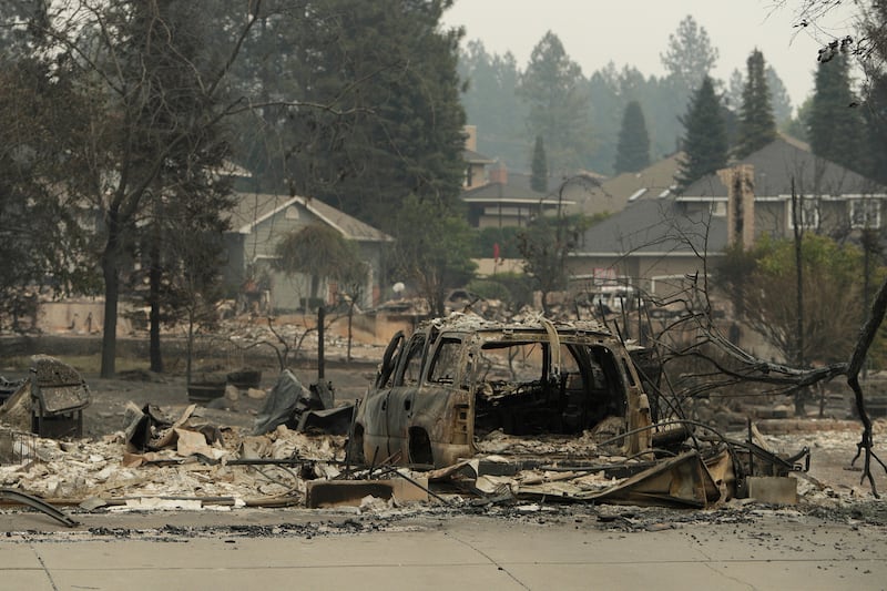 Um veículo e uma estrutura queimados na North Skyline Drive devido a um incêndio florestal, domingo, 2 de agosto de 2026, em Spokane, Washington.