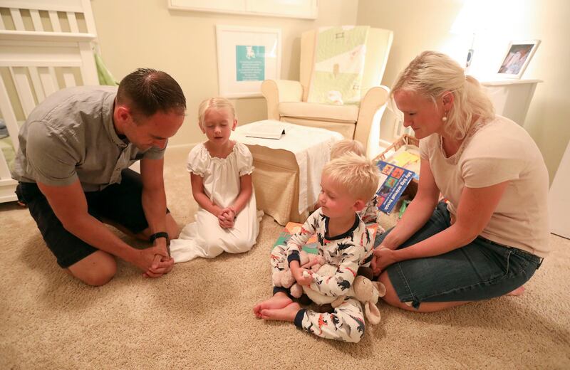 Spencer, Izzie, Luke, Liam e Mary Thompson ajoelhados, oram juntos em sua casa em Millcreek, Utah, na segunda-feira, 30 de julho de 2018. Dados da Pesquisa Mundial Gallup divulgados em outubro de 2023 encontraram uma “forte associação” entre a religiosidade, a importância da religião na vida diária de uma pessoa, e bem-estar.
