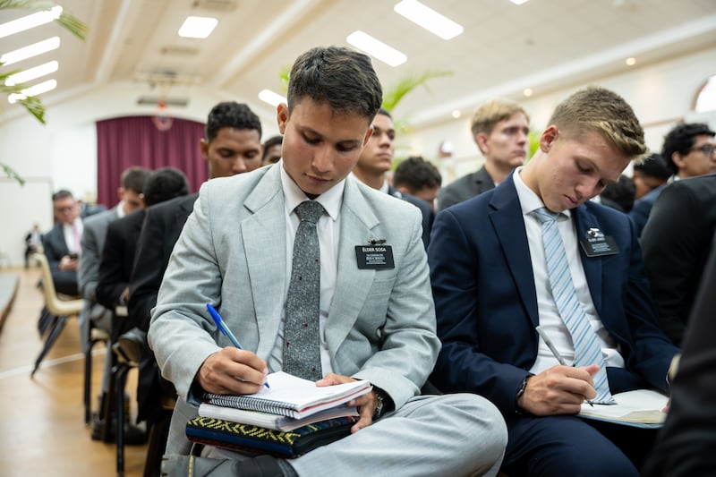 Missionários anotam observações enquanto assistem o devocional com Élder Ronald A. Rasband do Quórum dos Doze Apóstolos em Manágua, Nicarágua, na sexta-feira, 16, 2026.
