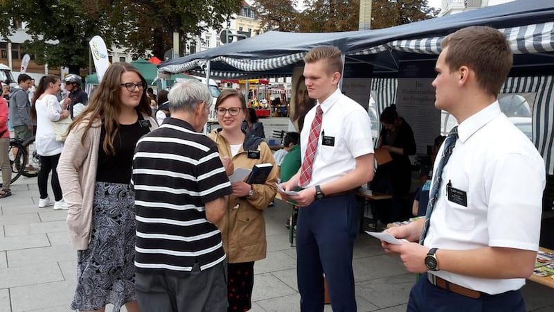 Missionários participando de um festival da família em Munique, Alemanha, em novembro de 2018 apresentam aos visitantes cópias de "A Família: Proclamação ao Mundo."