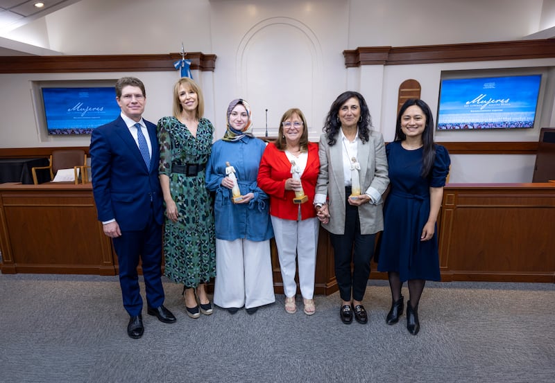 Elder Alan R. Walker, Sister Inés Walker, Sümeyra Nur Korkur, Cecilia Blanco de Di Lascio, Silvina Chemen e Jorgelina Benavidez posam juntos para uma foto após a cerimônia "Women who Illuminate" em Buenos Aires, Argentina, 19 de março de 2026.