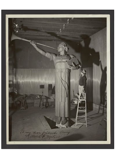 Millard F. Malin em uma escada ao lado de sua estátua do Anjo Morôni, em aproximadamente 1956. Esta estátua foi colocada no Templo de Los Angeles Califórnia.