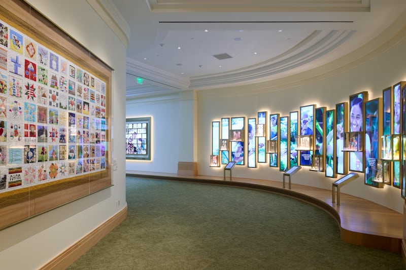 As paredes do nível inferior do Centro de Visitantes da Praça do Templo em Salt Lake City contêm vídeo, fotos, áudio e "The Family Quilt". As portas abriram ao público em 18 de maio de 2026.