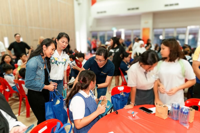 Voluntários da Igreja de Jesus Cristo dos Santos dos Últimos Dias distribuem sacos de rações secas no projeto de serviço Study Awards no West Coast Community Centre em Singapura, 6 de dezembro de 2025.