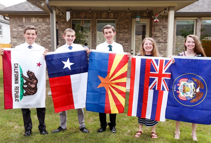 Joshua, Jonathan, Joseph, Nataleigh e Cathryn Faylor seguram bandeiras de suas designações missionárias em sua casa em San Antonio, no domingo, dia 20 de junho de 2021.