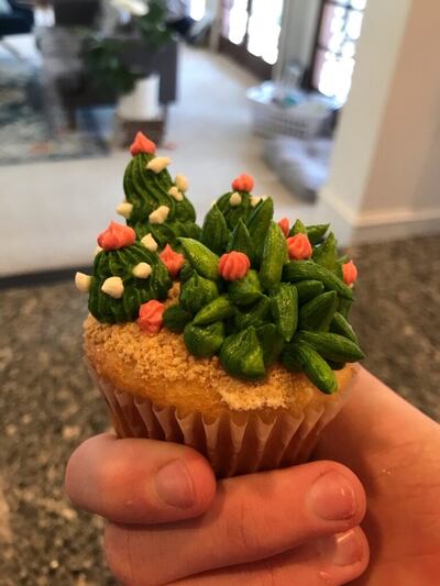 Uma moça da Ala Canyon Rim 2 em Salt Lake City, Utah, segura um cupcake (bolinho) que decorou durante uma atividade virtual de jovens, em maio de 2020.