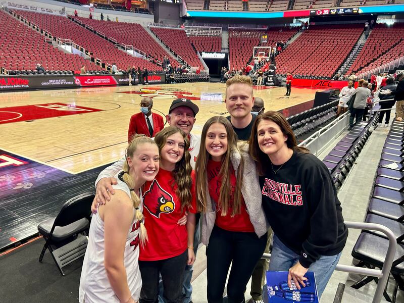 Josie Williams, de Louisville, à esquerda, tira uma foto com sua família depois de um jogo.