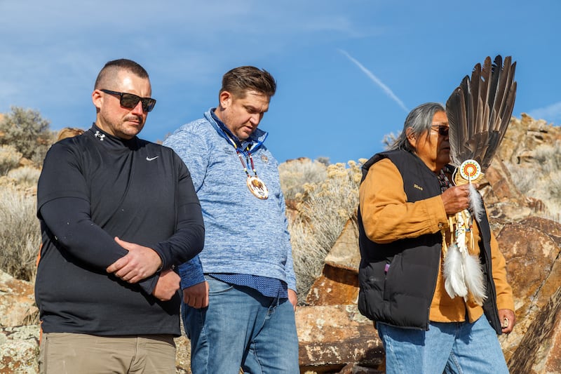 Membros da Banda Noroeste da Nação Shoshone fazem uma pausa para uma bênção de Rios Pacheco, um líder espiritual tribal à direita, durante a repatriação de uma pedra sagrada com petróglifos criados por seus antepassados. A pedra foi levada há cerca de 80 anos e colocada em uma capela de A Igreja de Jesus Cristo dos Santos dos Últimos Dias em Tremonton, Utah. A Igreja mandou limpar e conservar a pedra na quinta-feira, 11 de dezembro de 2025, perto da fronteira Utah-Idaho.