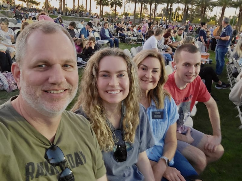Irmã Kim Ward, segunda da direita, sorri para uma foto com sua família em uma encenação da Páscoa no gramado da frente do Templo de Mesa Arizona, abril de 2025.