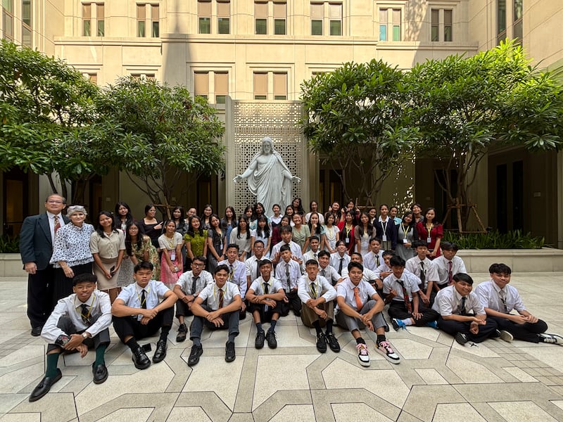Jovens da Indonésia posam para uma foto fora do Templo de Bangkok, Tailândia, enquanto visitam os jardins em 17-18 de dezembro de 2025.