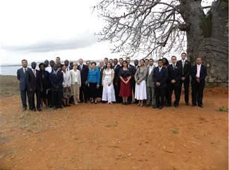 Líderes da Igreja, membros e missionários posam para uma foto em frente a um grande baobá com centenas de anos em Angola, África, depois que Élder D. Todd Christofferson, do Quórum dos Doze, ofereceu uma bênção sobre o país e seu povo.