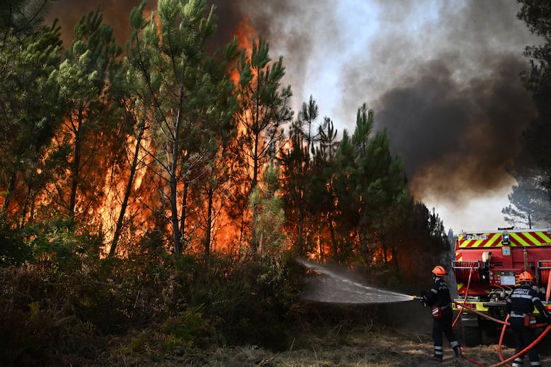 Os bombeiros trabalham para extinguir um incêndio na floresta perto de Blagon, durante incêndios florestais no sudoeste da França, quarta-feira, 29 de julho de 2026.