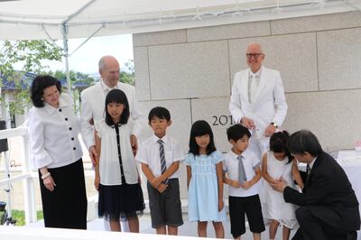 Durante a cerimônia de colocação da pedra de esquina no Templo de Sapporo Japão, o Presidente Russell M. Nelson e sua esposa, a irmã Wendy Nelson, estavam com algumas crianças convidadas a participar: da esquerda para a direita, Kuhi Kikuchi, 10 anos; Ryuto Miyamoto, 8; Hina Iwamoto, 7; Kaito Miyamoto, 6; e Miku Nigita, 4, que é assistida por seu pai, Haruhiko Nigita. O Élder Larry Y. Wilson dos Setenta está atrás deles olhando para frente.