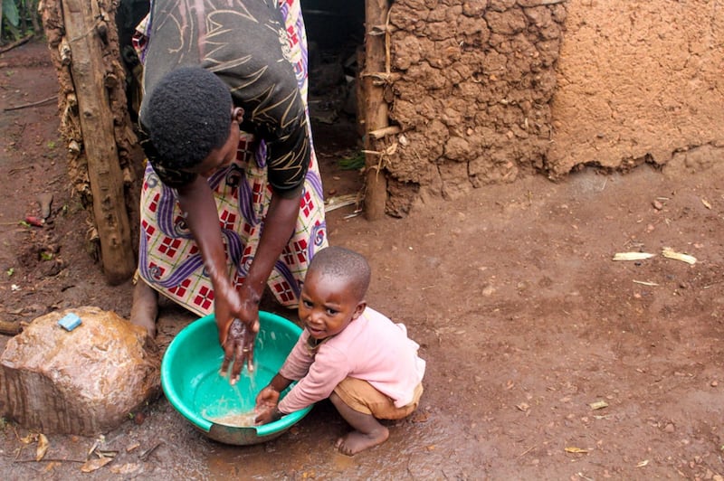 Priscilla, de quatro anos, lava as mãos na água recolhida de uma fonte, no distrito de Gicumbi, em Ruanda. A Igreja de Jesus Cristo dos Santos dos Últimos Dias e a Water for People estão trabalhando com o governo de Ruanda para instalar mais fontes de água na área, ainda em 2023.