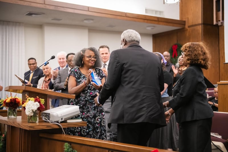 Sabra Stewart-Johnson apresenta a Vernon e Linda James um prêmio de serviço por todo o seu trabalho com o Fort Worth Save Our Children Learning Center no devocional Saints in Unity em Fort Worth, Texas, em 16 de novembro de 2025.